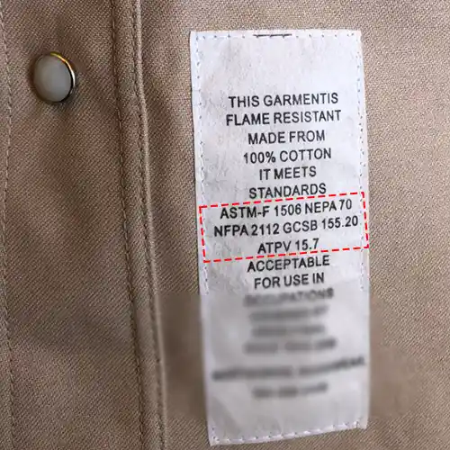 The care label inside a flame-resistant shirt, listing ASTM F1506, NFPA 70E, NFPA 2112 and an ATPV of 15.7